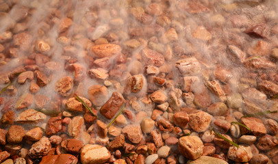 Pebbles on beach against waves