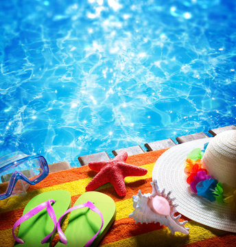 summer holidays in pool - with towel, sandals, hat and shell
