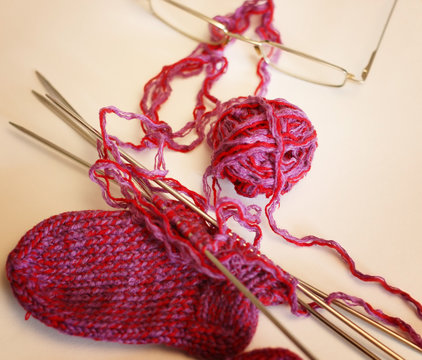 red ball of yarn knitting needles to knit socks