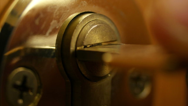 Key sliding into lock and locking\ unlocking door. 4K UHD video.