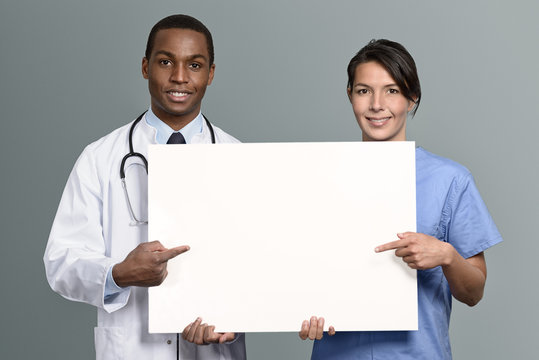 Multi-Ethnisches Mediziner Team h&auml;lt ein wei&szlig;es Plakat