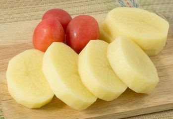 Fresh Potatoes and Tomatoes on Wooden Board