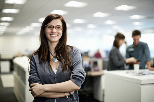 A woman with arms folded smiling.