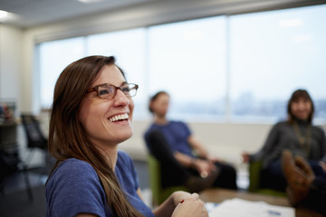 A woman laughing with her colleagues.