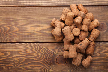 Heap of champagne corks over rustic wooden table background