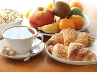 Breakfast with coffee, croissant, muesli and fruits