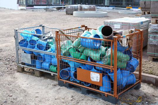 Gitterbox mit Plastikrohren auf Baustelle