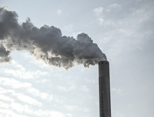 Smoke clouds from a high concrete chimney