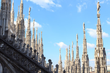 Fototapeta na wymiar Statues on Milan Cathedral and blue sky