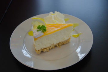A piece of lemon cheese cake on white plate