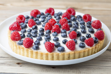 Cake with blueberries and raspberries. Confectionery product.