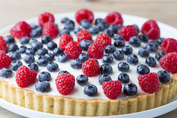 Cake with blueberries and raspberries. Confectionery product.