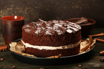 Delicious chocolate cake on table on brown background