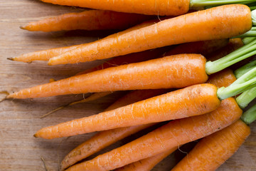 Fresh carrots on the wooden background.
