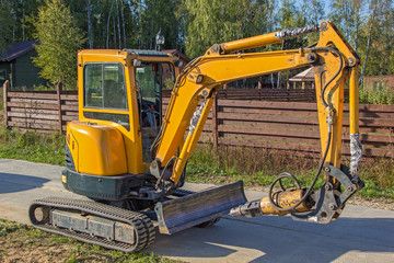 small yellow crawler excavator for screwing piles © hdmphoto