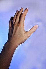 Female hand and blue shadow on light colorful background