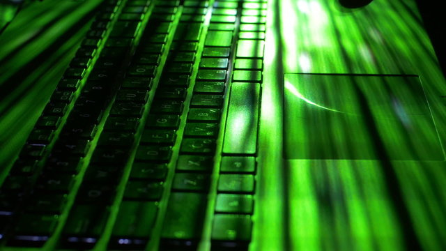 The man work with the laptop backlight keyboard
