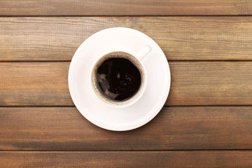 Fototapeta na wymiar Cup of coffee on wooden table, top view