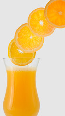 orange juice in glass and orange slices side flow