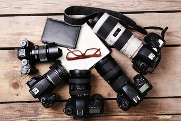 Still life with modern cameras on wooden table, top view
