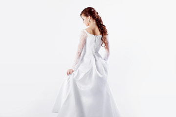 Beautiful bride in wedding dress, back, white background