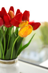 Bouquet of fresh tulips on windowsill background
