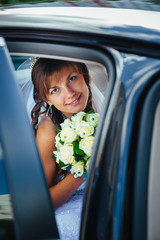 close-up portrait of pretty shy bride in a car window