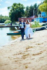 Fototapeta na wymiar loving wedding couple standing and kissing near water