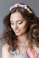 Smiling  girl with lush hair with a rim of bright colors