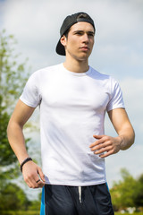 Young man running and jogging on road in country