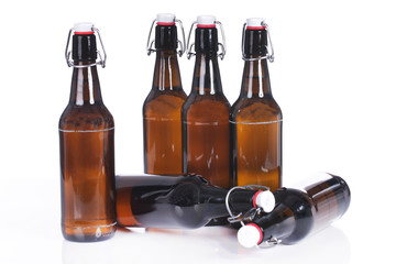 Sechs volle Bierflaschen stehen und liegen isoliert