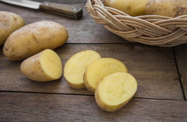 Potato and slices on wooden table