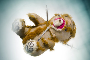 Teddybär mit Spritzen liegend