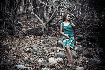 Portrait of a beautiful young woman in turquoise dress standing