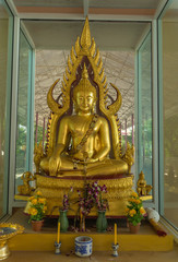 gold buddha statue sitting with candlestick and incense burner