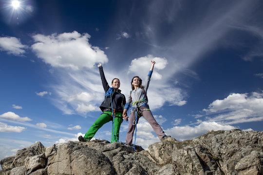 Group of two happy female climbers  celebrates victory