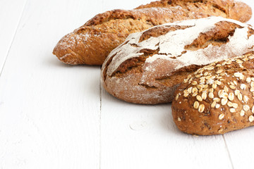 Mixed whole grain health breads on rustic painted wood.