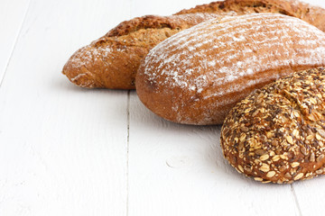 Mixed whole grain health breads on rustic painted wood.