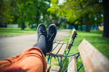 The legs of a woman lying on a bench