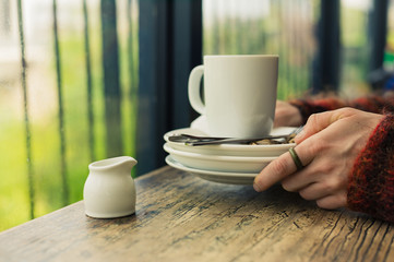 Woman with empty plates and mug
