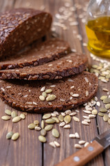 Traditional dark bread with sunflower seeds on a wooden table.