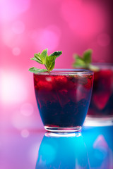 Raspberry and blackberry cocktail with mint garnish. Studio shot