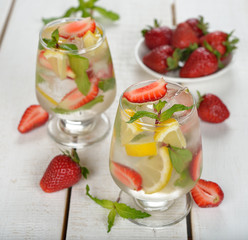 Cold drink with strawberries, lemon and mint