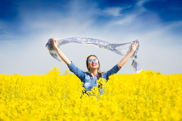 Young happy girl with a scarf in the field