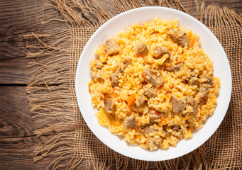 A delicious pilaf in a dish on the old board