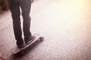 Boy cruising on a longboard at sunset