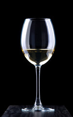 Glass of white wine on a black background