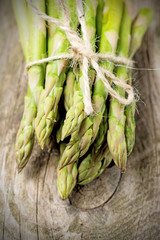 Asparagus on wooden table tied up with twine string
