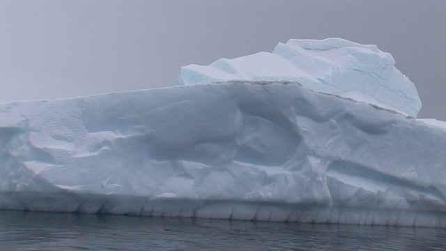Sailing pass near by big iceberg, Paradise Harbour, Antarctica