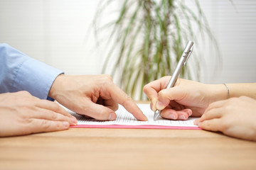 man is pointing a place where she should sign the agreement